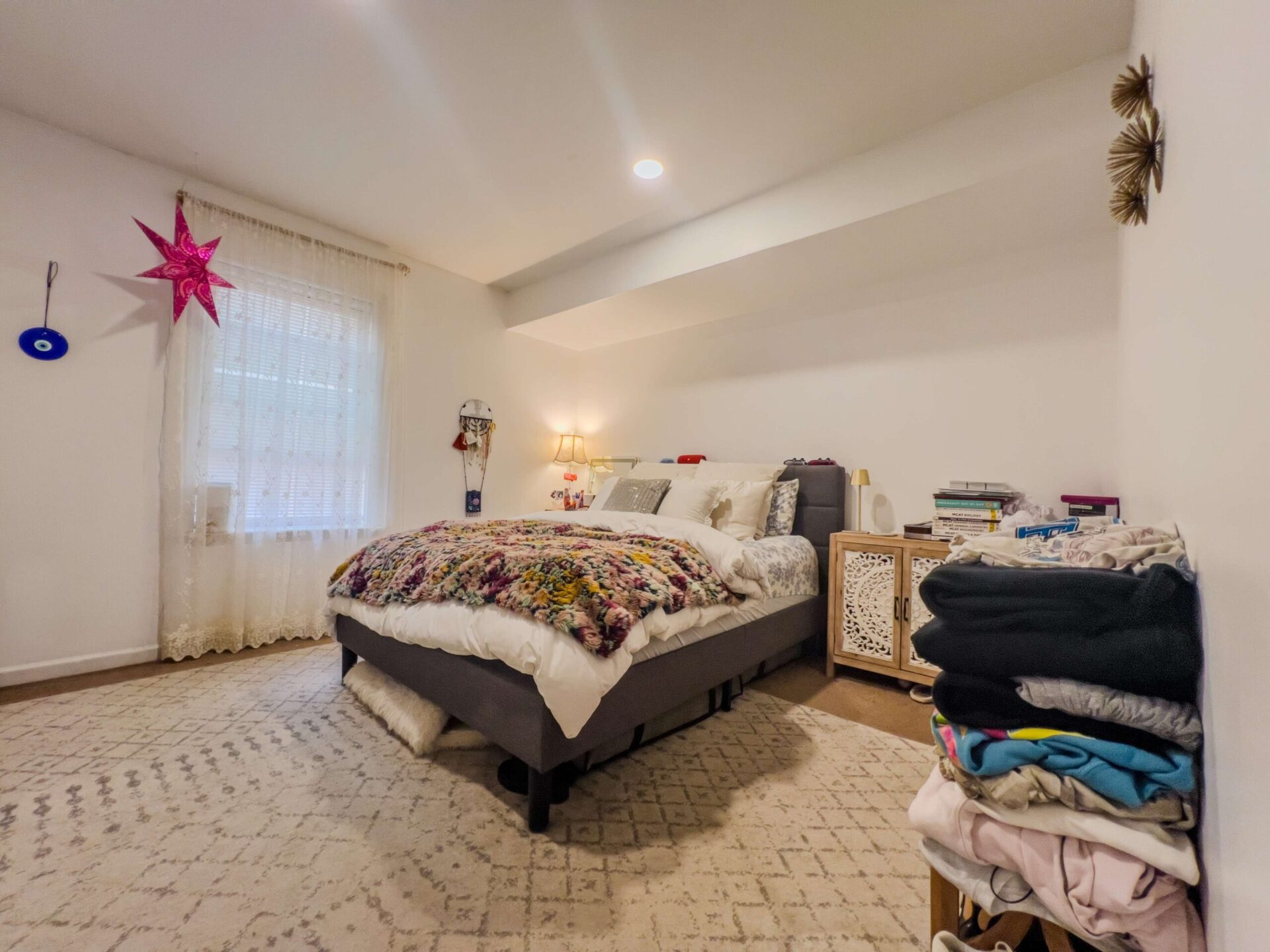 A lived-in bedroom in a templevillas.com apartment with a queen bed and large window